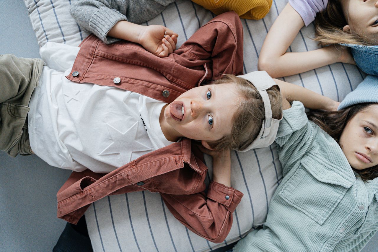 The Art of Drawing Readers In: Your attractive post title goes here A candid shot of playful children lounging indoors, showcasing carefree youth.